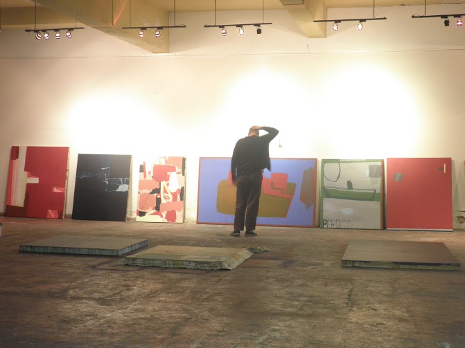Enrique Ciapara observando una serie de piezas terminadas en su estudio